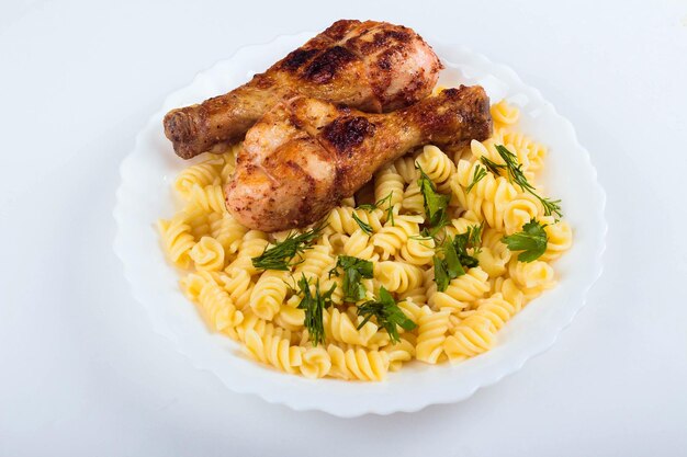 Coscia di pollo alla griglia e pasta su sfondo bianco piatto bianco