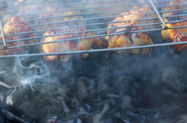 Coscia di pollo alla griglia sopra le fiamme su un barbecue.