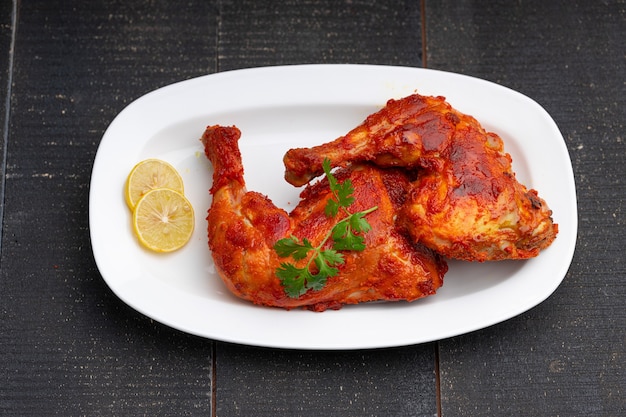 Coscia di pollo fritta o coscia di tamburo friggere il pollo indiano piccante con sfondo nero