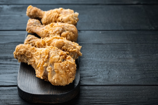 Coscia di pollo fritto croccante su fondo di legno nero