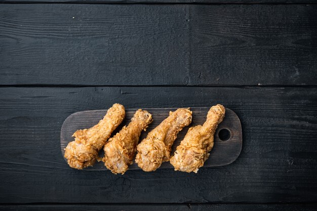 Coscia di pollo impanata e fritta su fondo di legno nero