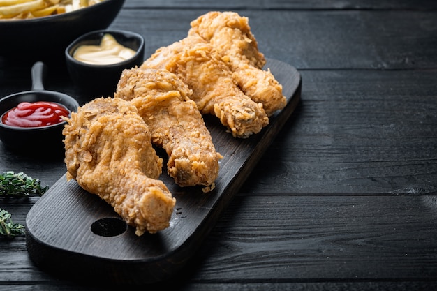 Coscia di pollo impanata e fritta sulla tavola di legno nera