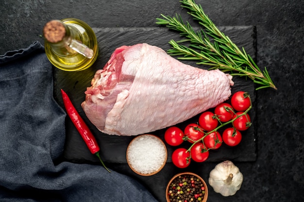 coscia di tacchino crudo con rosmarino sul tavolo di pietra