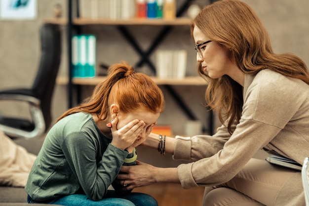 Così triste. Bella ragazza dai capelli rossi che piange mentre mostra le sue emozioni