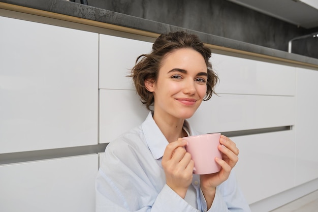 Cosiness e concetto di casa giovane donna si gode la sua tazza di caffè mattutino beve tè fresco e sorrisi f