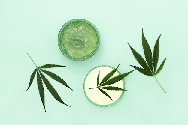 Cosmetici a base di cannabis, vasetto con crema o gel per il corpo e foglia naturale di cannabis