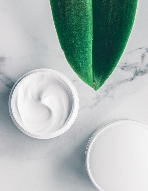 Cosmetici di bellezza organici su sfondo flatlay in marmo per la casa spa