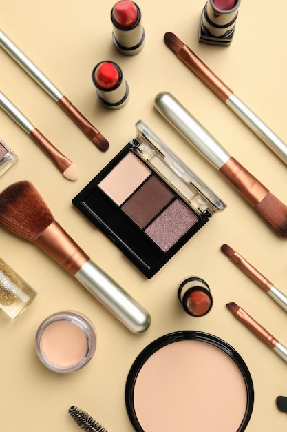 Cosmetici differenti di trucco su fondo beige. Accessori femminili