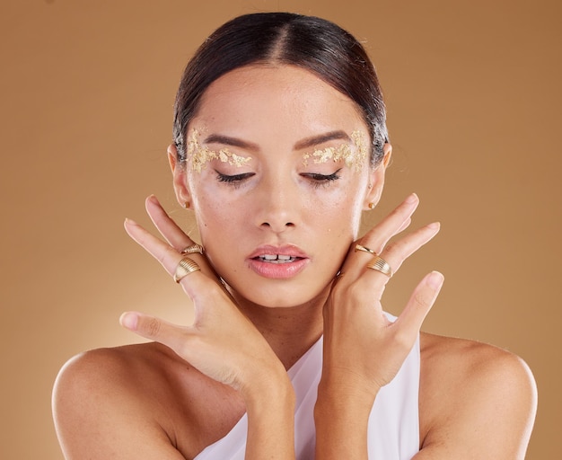 Cosmetici dorati glitter per il viso e donna con ombretto di lusso prodotto per il trucco e bagliore per la cura della pelle in studio Salone di bellezza spa e modello estetico ragazza con accessori per anelli di gioielli o assistenza sanitaria alla vitiligine