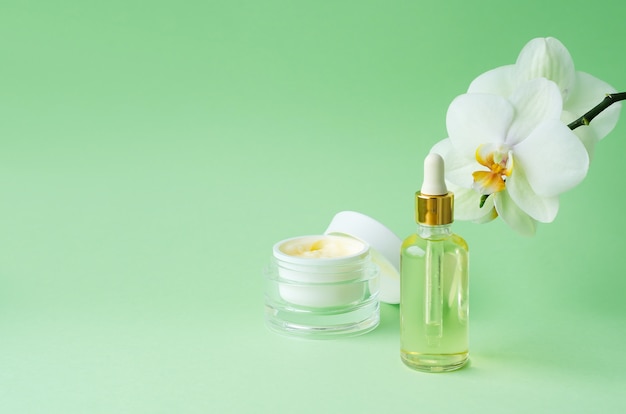 Cosmetici naturali antietà, antirughe, per la giovinezza, elasticità della pelle su sfondo verde. crema, maschera in barattolo, siero, liquido, olio in bottiglia. cura del viso e del corpo. banner, modello, copia spazio