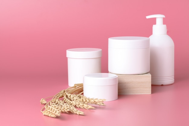 Cosmetici naturali e foglie sul rosa