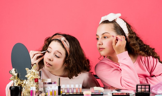 Cosmetici per bambini Festa in spa Bellezza e moda Ragazze felici che si truccano insieme Salone di bellezza Gioca con i cosmetici Negozio di cosmetici Felicità della sorellanza Cura della pelle Prevenire l'acne Trucco per bambini