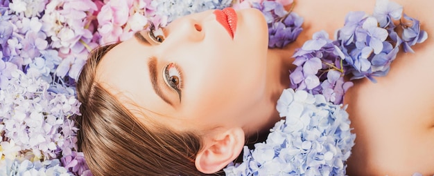 Cosmetici per il trucco e cura della pelle natura bellezza donna sdraiata sui fiori unità con la natura fiore ragazza wi