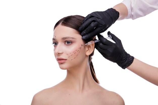 Cosmetologia concetto di bellezza bella giovane donna viso e mano con siringa che fa iniezione