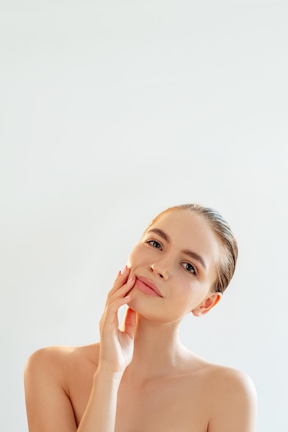 Cosmetologia naturale Terapia termale Ritratto di donna rilassata con trucco nudo spalle nude che toccano la pelle perfetta isolata su sfondo bianco chiaro copia spazio Pulizia del viso Bellezza benessere