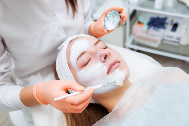 Cosmetologo che applica maschera sul viso del cliente nel salone termale Centro benessere Occupazione sanitaria