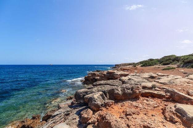 Costa bassa molto dolcemente digradante dell'isola di Ibiza e mare turchese trasparente Isole Baleari Spagna