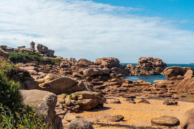 Costa con la bassa marea lungo Mean Ruz lighthouse, porto di Ploumanach, nella città di Perros-Guirec, Cotes-d'Armor, nella Bretagna francese, Francia.