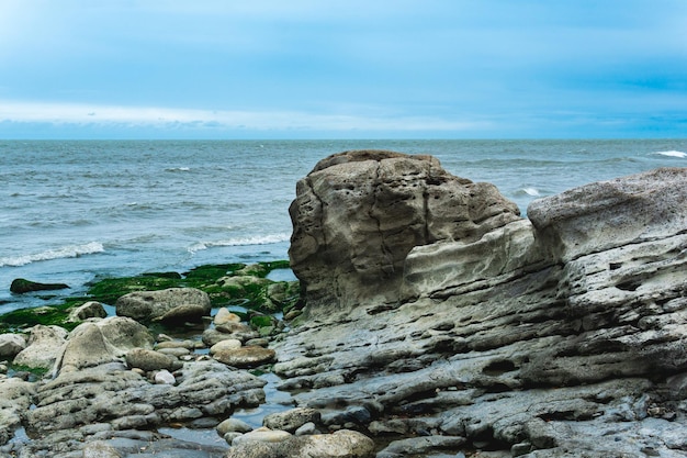 Costa del Mar Caspio con rocce costiere e pietre ricoperte di alghe