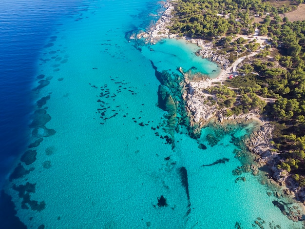 Costa del Mar Egeo con rocce vicino alla riva e sotto l'acqua blu trasparente, verde, vista dal fuco, Grecia