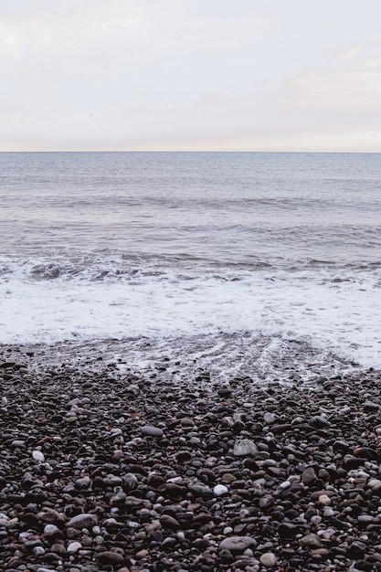 Costa di pietra con schiuma bianca del mare