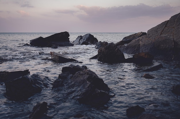 Costa rocciosa del mare al tramonto