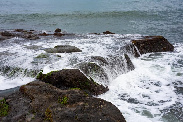 Costa rocciosa del mare colpita dalle onde sull'isola di Bali