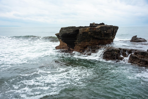 Costa rocciosa del mare colpita dalle onde sull'isola di Bali