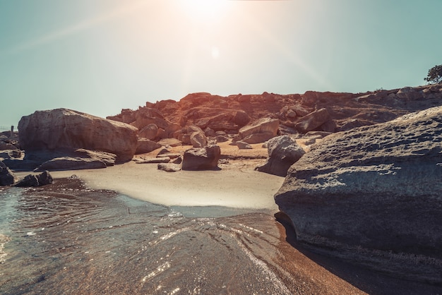 Costa rocciosa del mare con acqua turchese sulla spiaggia