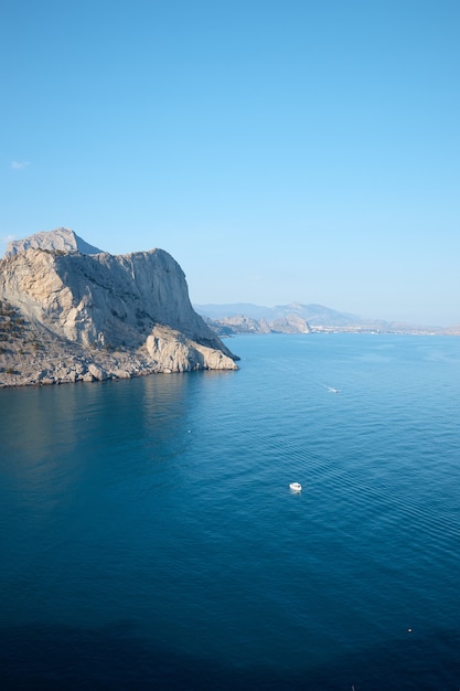 Costa rocciosa nel mare, spiaggia selvaggia e montagne, la roccia va in acqua, vista mare, paesaggio selvaggio