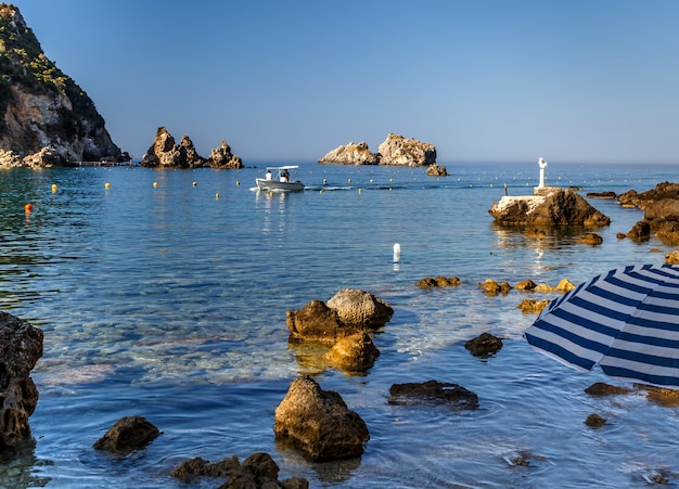 Costa rocciosa nell'isola di Paleokastritsa Corfù Grecia Chiare acque azzurre in barca in mare vacanze estive