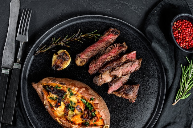 Costata di manzo guarnita con patate dolci al forno. Arrosto di manzo. Carne di fattoria biologica.