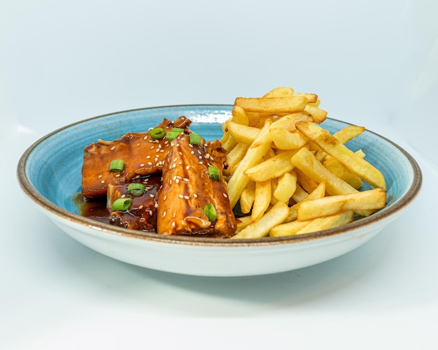 Costillitas de chancho alla barbacoa con patatas fritas.