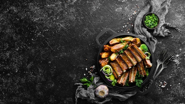 Costine di maiale al forno con patate in padella Barbecue Vista dall'alto Spazio libero per il testo