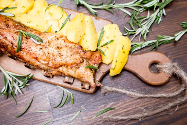 Costine di maiale al forno con patate, rosmarino e un bicchiere di birra