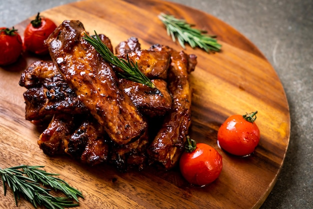 costine di maiale grigliate al barbecue con rosmarino e pomodori