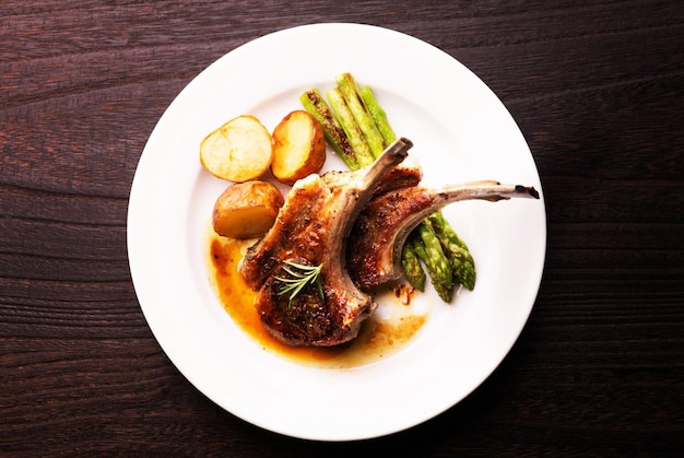 Costolette di agnello alla griglia biologiche con patate e asparagi