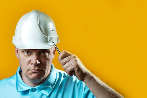 Costruttore brutale dell'uomo in un casco bianco su giallo