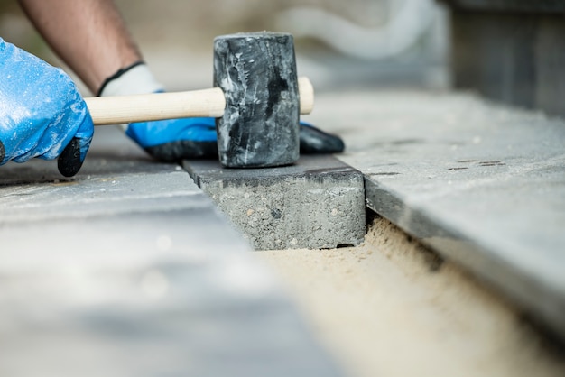 Costruttore che pone una pietra per lastricati o un mattone