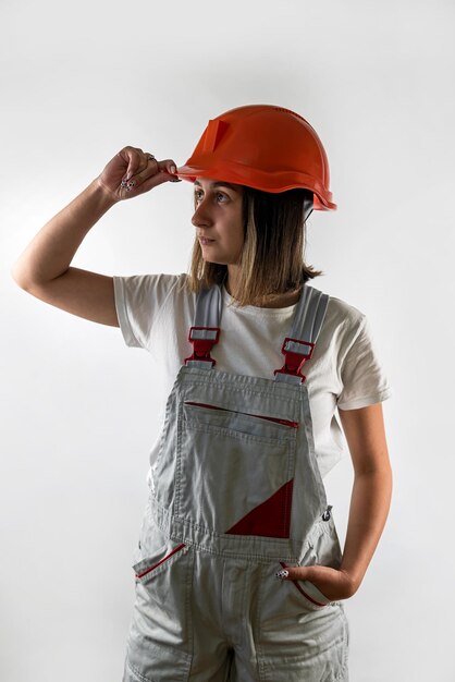 Costruttore di giovane architetto femminile in posa in uniforme e casco sorridente