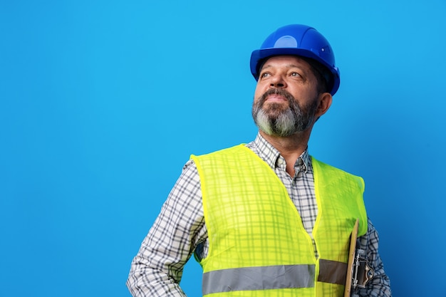 Costruttore maschio o tuttofare in uniforme che tiene appunti su sfondo blu