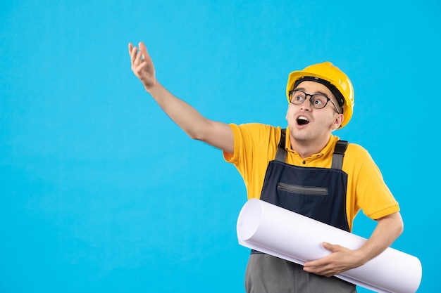 Costruttore maschio vista frontale in uniforme con piano di carta sul blu