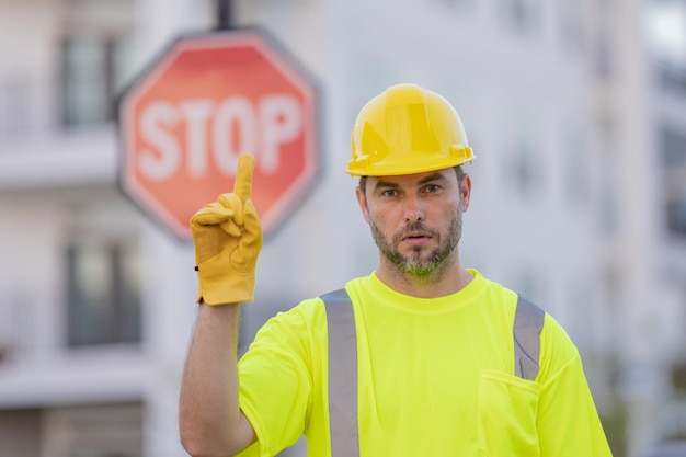 Costruttore serio con segnale stradale di stop costruttore con gesto di stop nessuna mano pericolosa sul concetto di costruzione