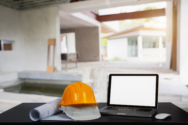 Costruzione casa e costruzione Lavoro di riparazione Dof computer portatile e costruzione di uffici sul tavolo in ufficio sfondo sfocatoArchitetto concetto