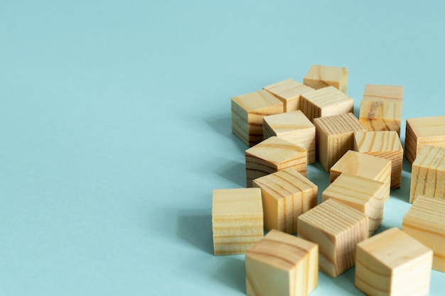 Costruzione di cubi di legno su sfondo blu con copia spazio. Composizione di mockup per il design