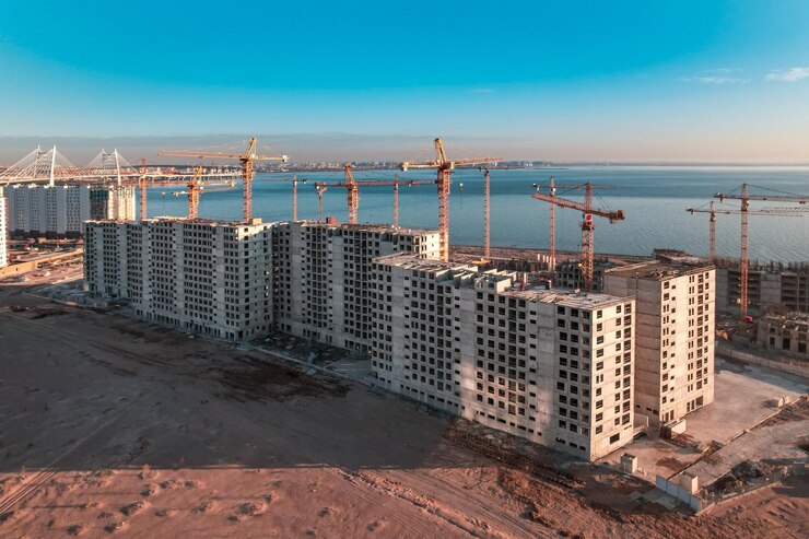 Costruzione di una casa a più piani in riva al mare Le gru edili erigono una casa sull'acqua