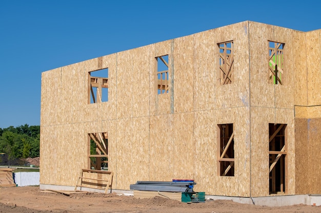 Costruzione di una nuova casa in compensato contro il cielo blu vero e proprio muro con struttura in legno