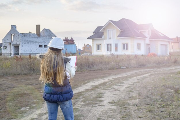 Costruzione in via di sviluppo e concetto di architettura donna in casco bianco con progetto e appunti