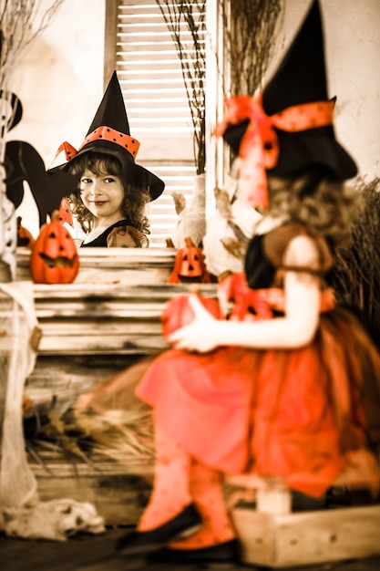 Costume da strega vestito bambino divertente che tiene la zucca. Concetto di vacanze di Halloween