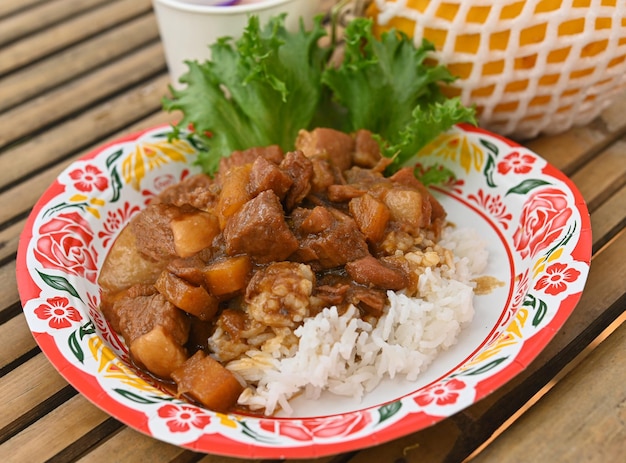 Cotoletta di maiale fritta al curry con riso sul tavolo di bambù